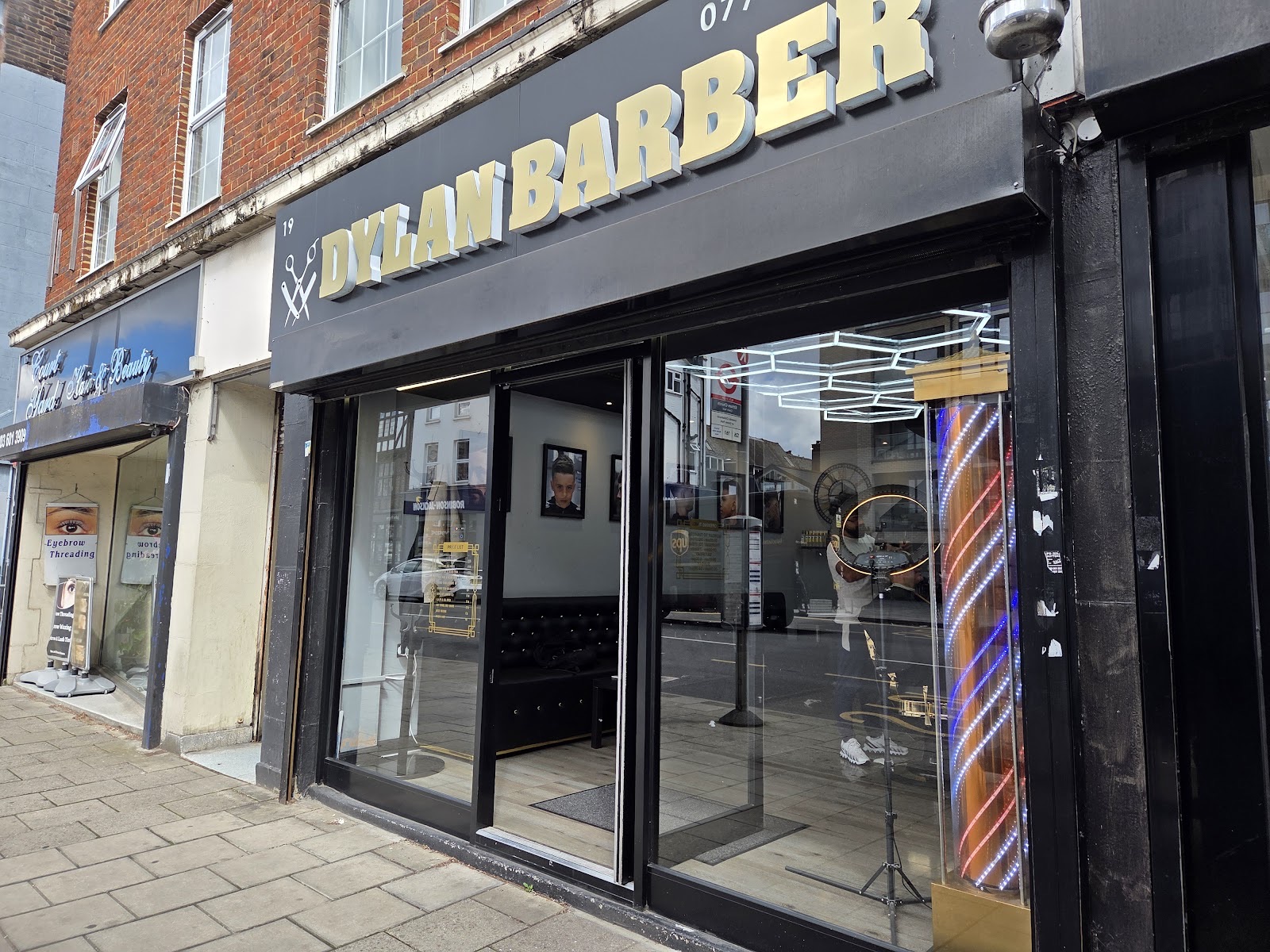 The shopfront of Dylan Barbers on Court Yard, with its barber's pole and full-height windows