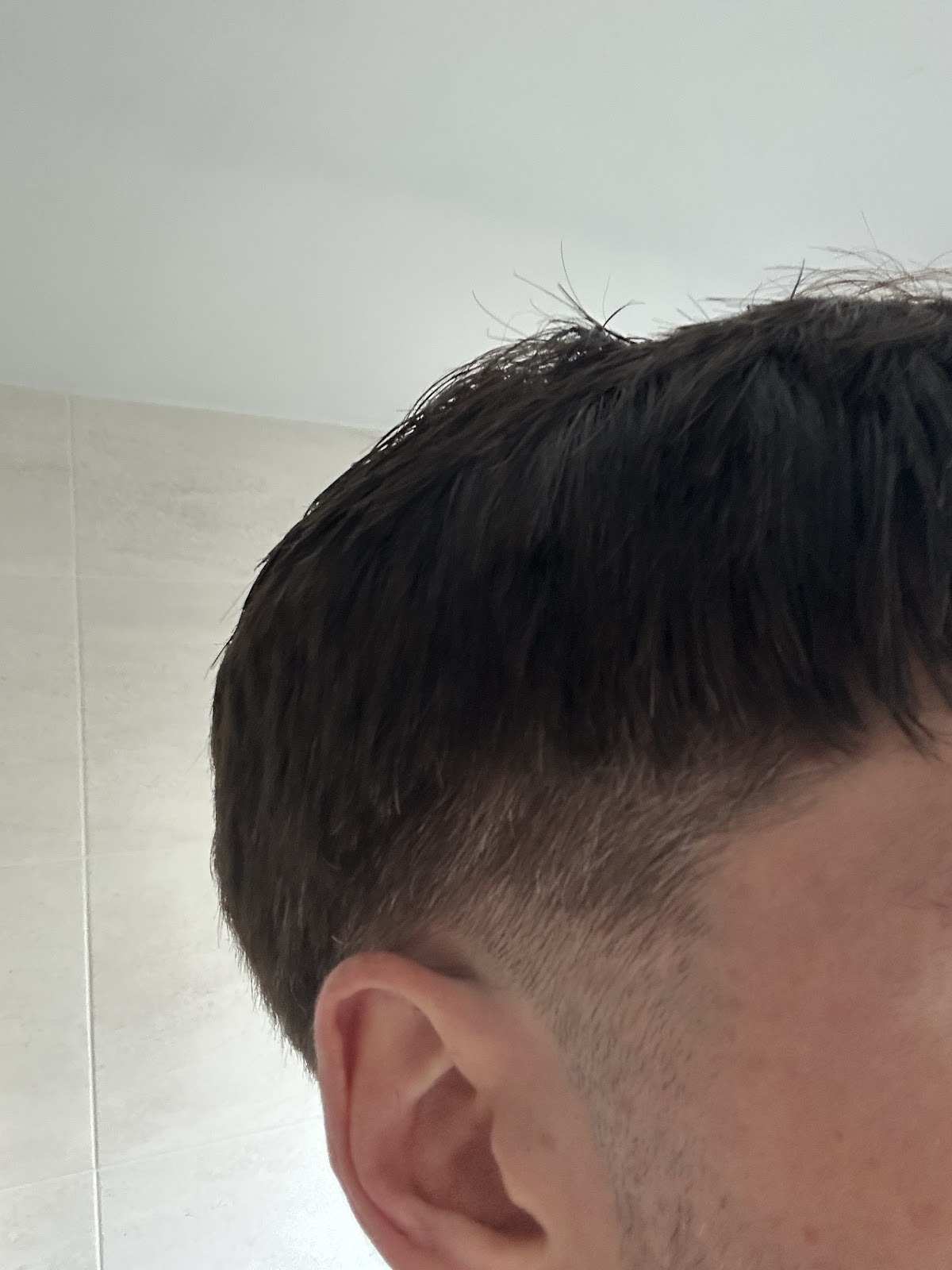Tight side view of a fresh fade and line-up around the ear
